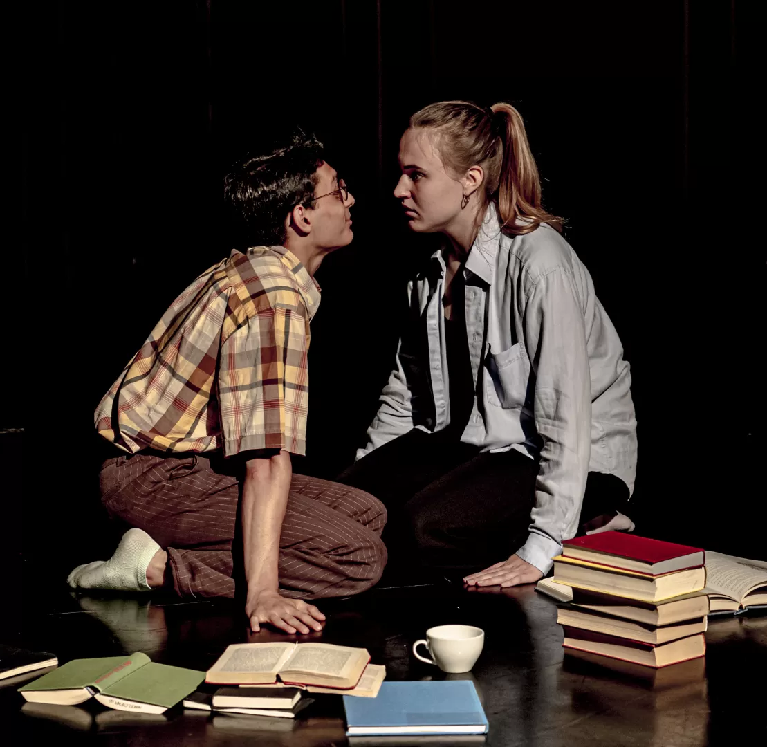 Ein Mädchen und ein Junge sitzen auf dem Boden und schauen sich an