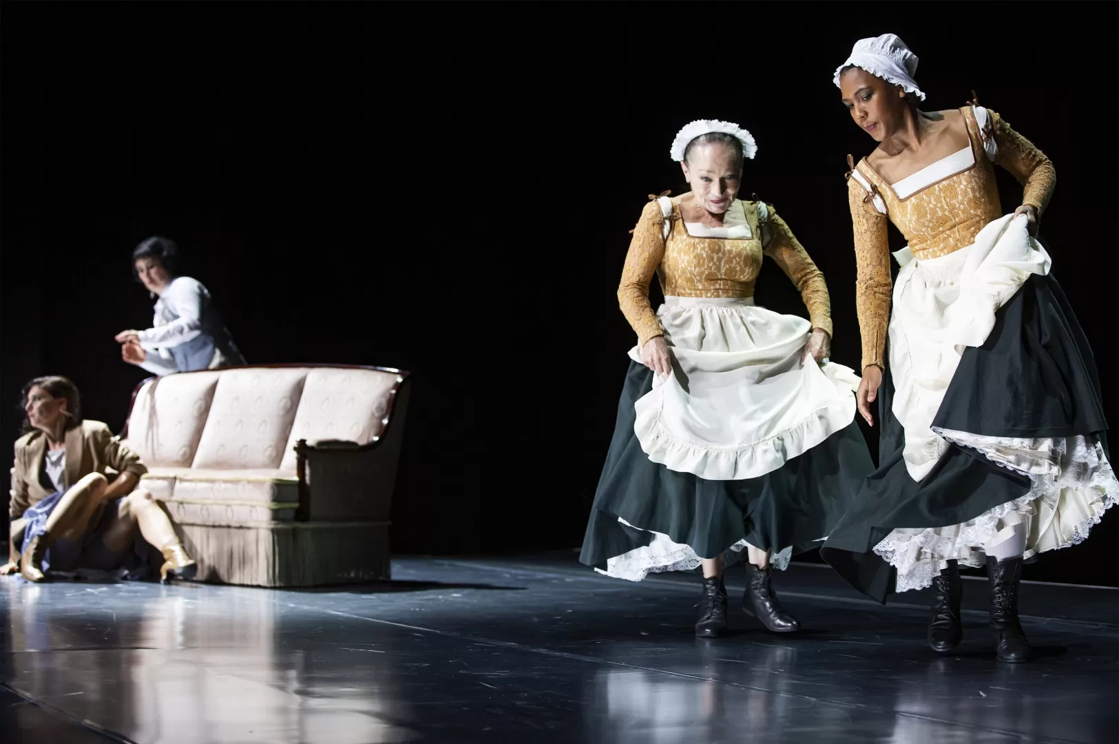 Zwei Frauen in Hausfrauenkleidung.