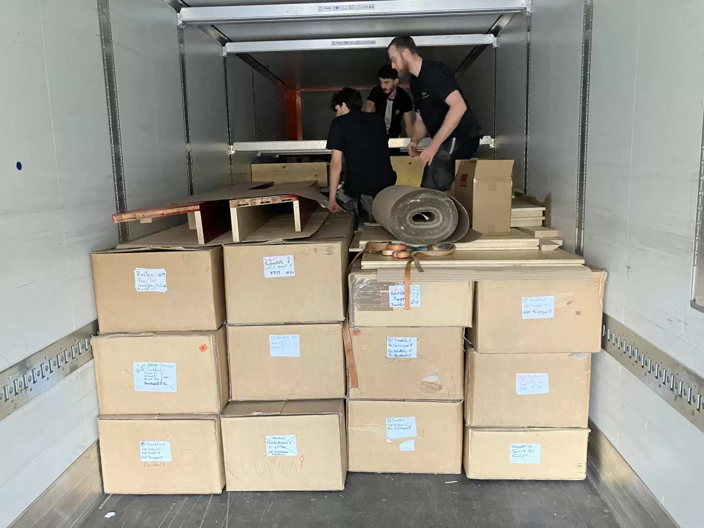 Die Handwerker*innen verstauen die Einzelteile der Orgel im LWK. Man sieht Kartons und Holzteile.