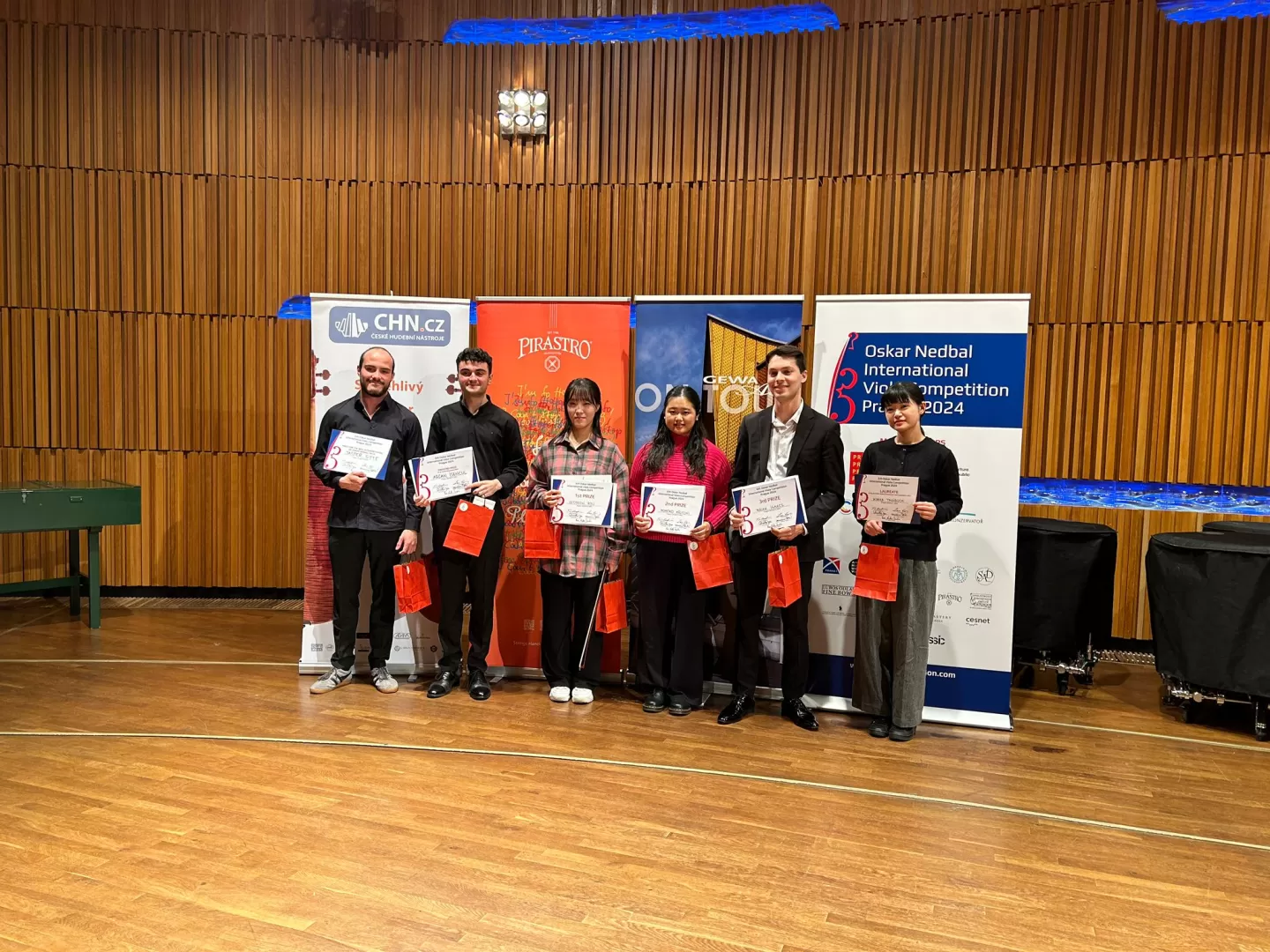 Sechs Preisträger*innen präsentieren sich mit ihren Urkunden.