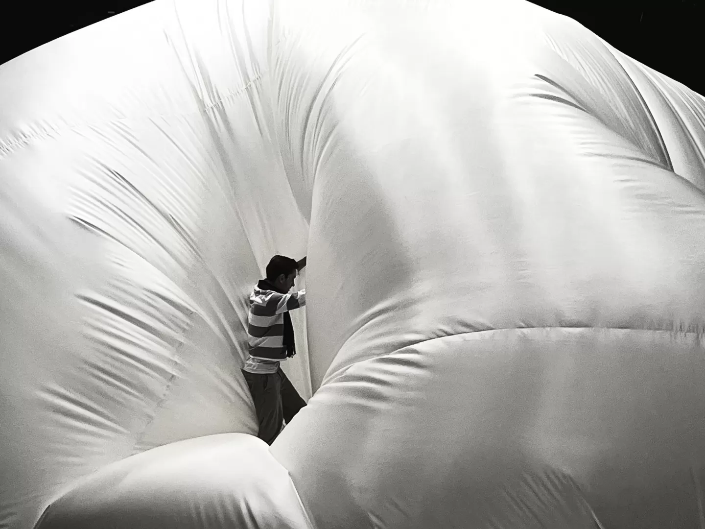 Ein Mensch läuft zwischen großen Planen lang