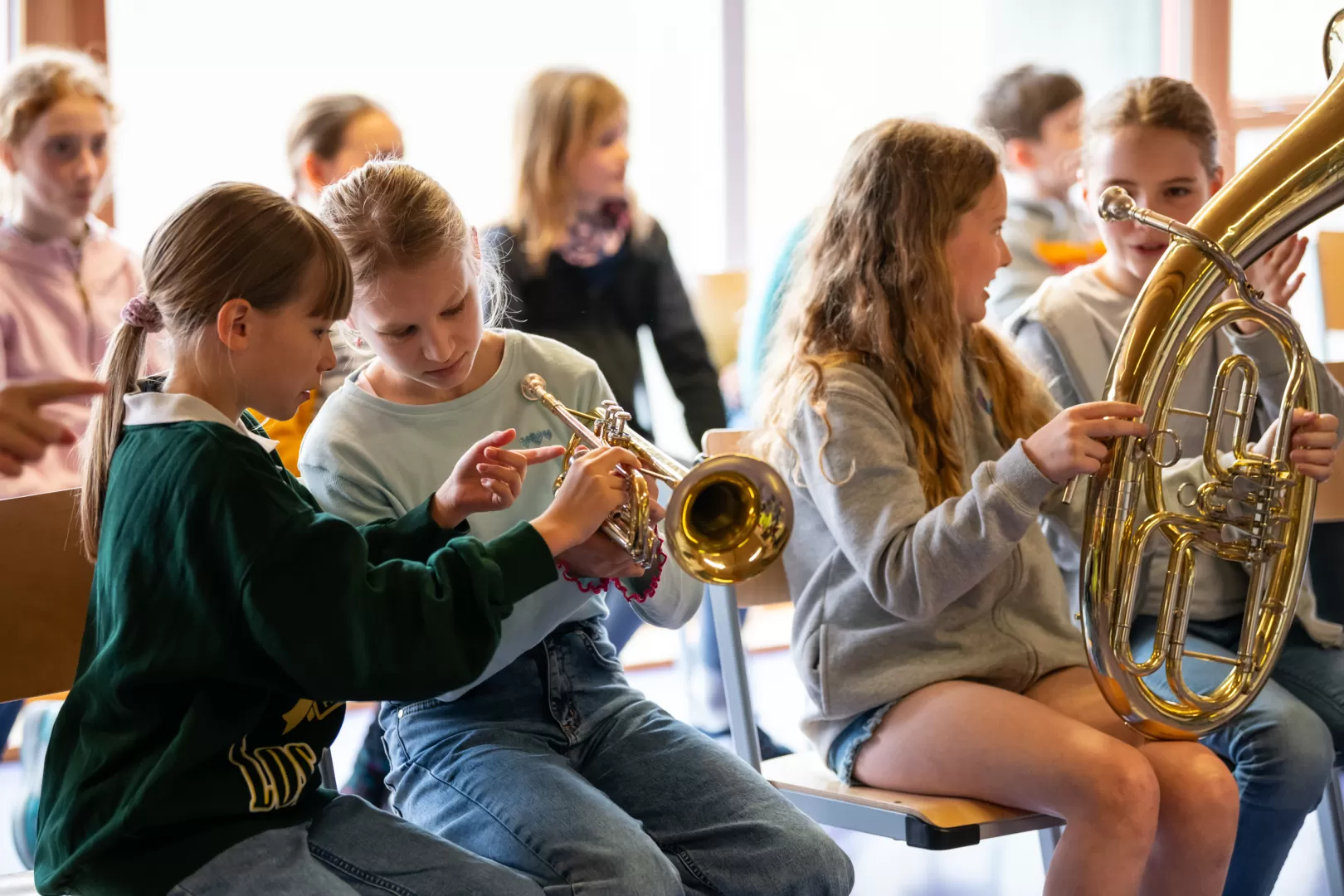 Zwei Schülerinnen schauen sich eine Trompete genauer an