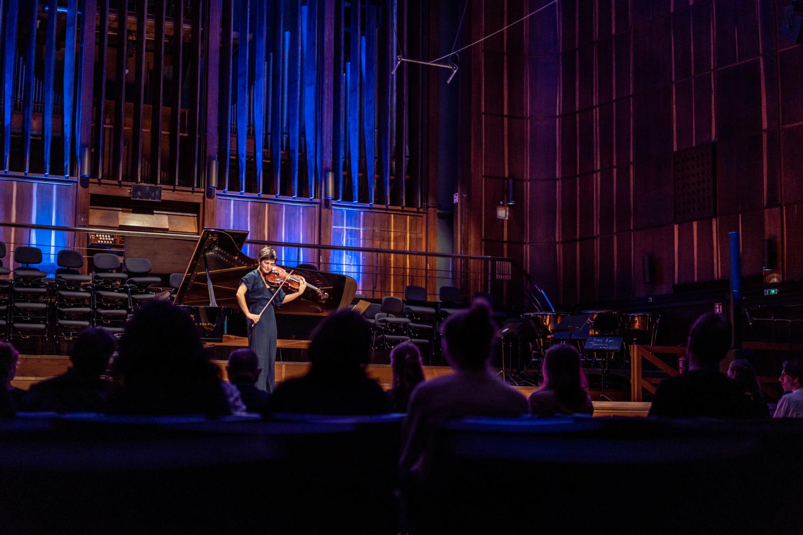 Eine Studentin spielt Viola bei einem Konzert auf der Bühne im Großen Saal.