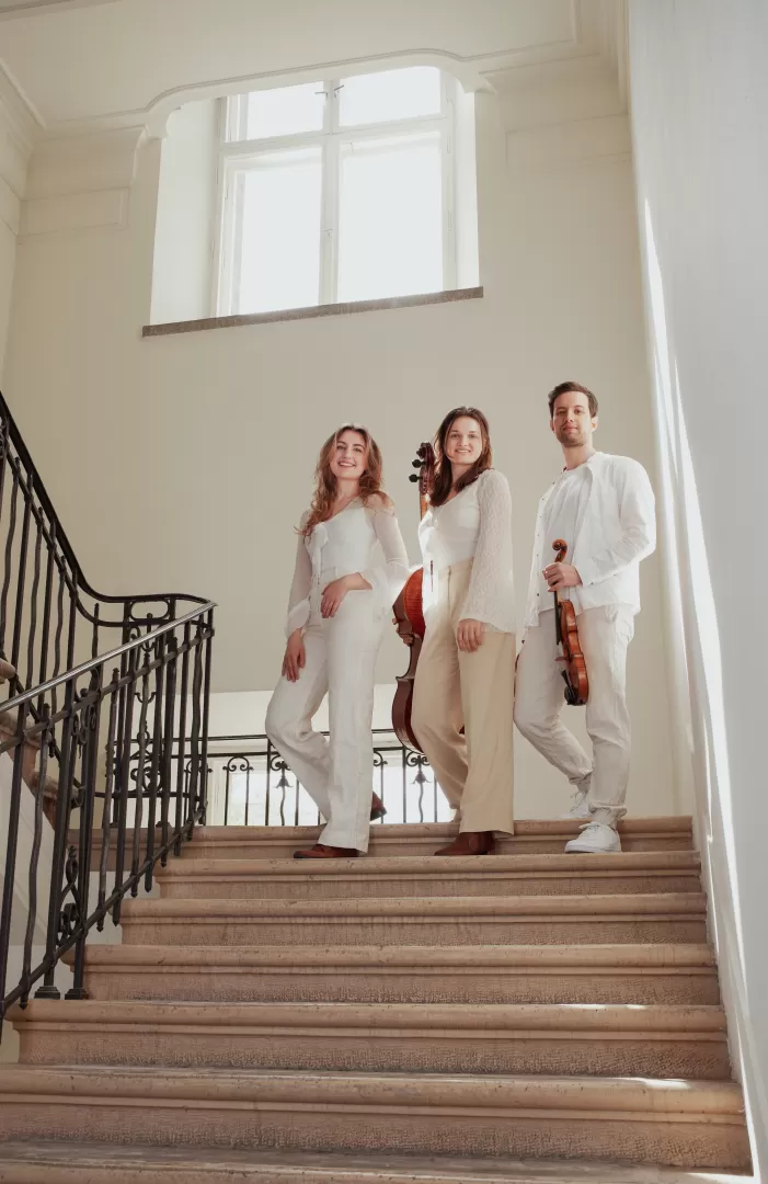 Die drei Musiker*innen des Bernstein Trios stehen auf einer Treppe.