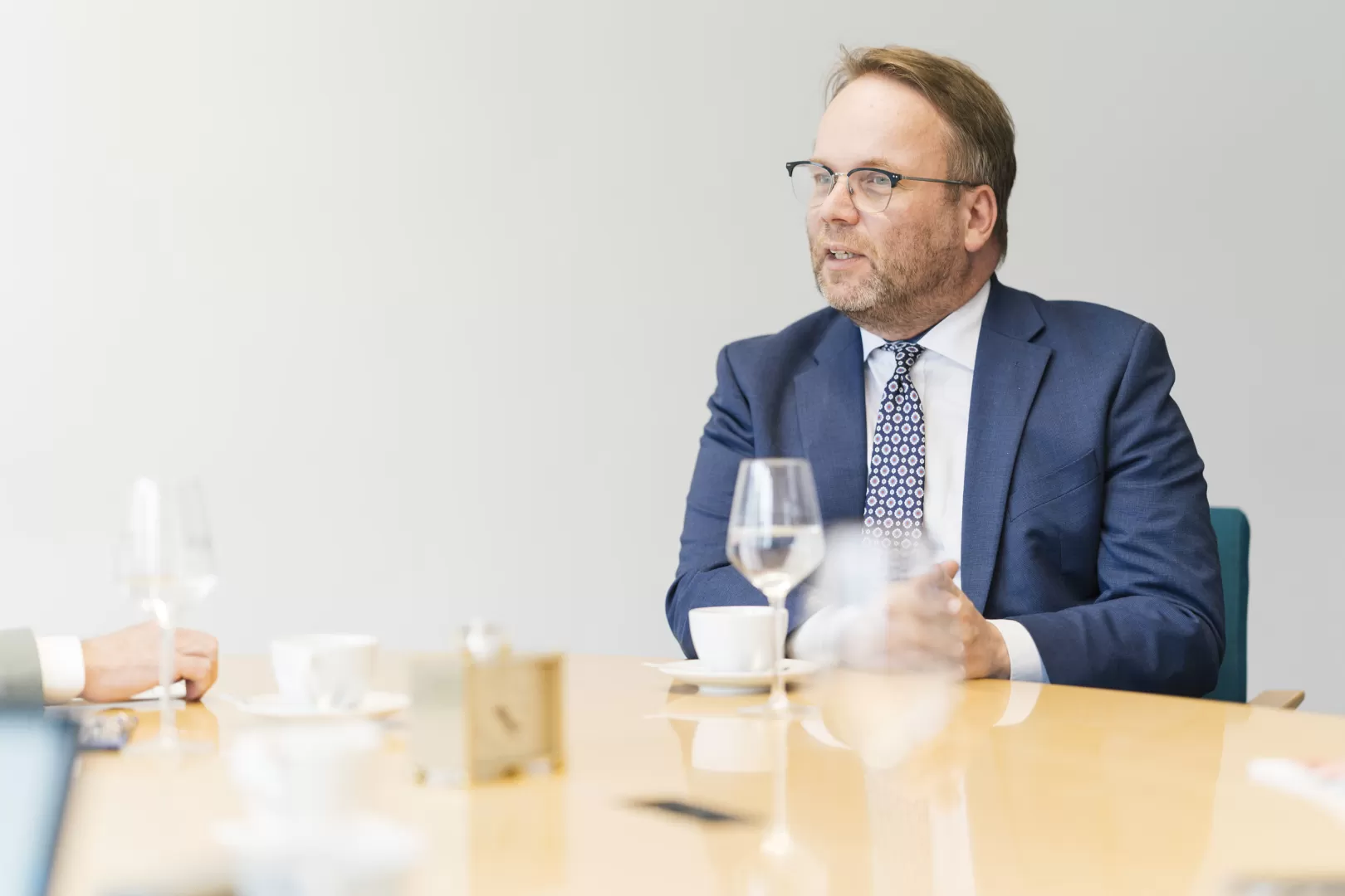 Timon Gremmels sitzt während dem Interview an einem Besprechungstisch, er trägt einen blauen Anzug.