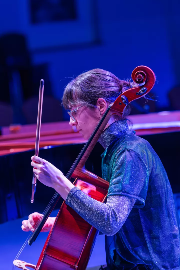 Die Cellistin spielt, umgeben von blauem Licht.