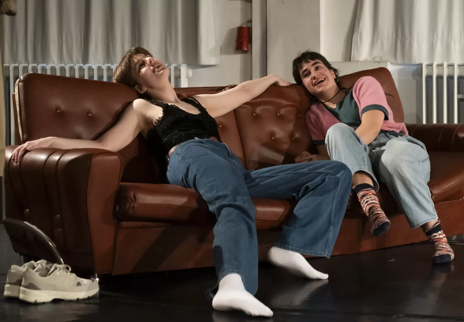 Paula Marie Schulze, Jeans, dunkelgrünes Top, auf braunem Ledersofa, daneben Dascha Dumont