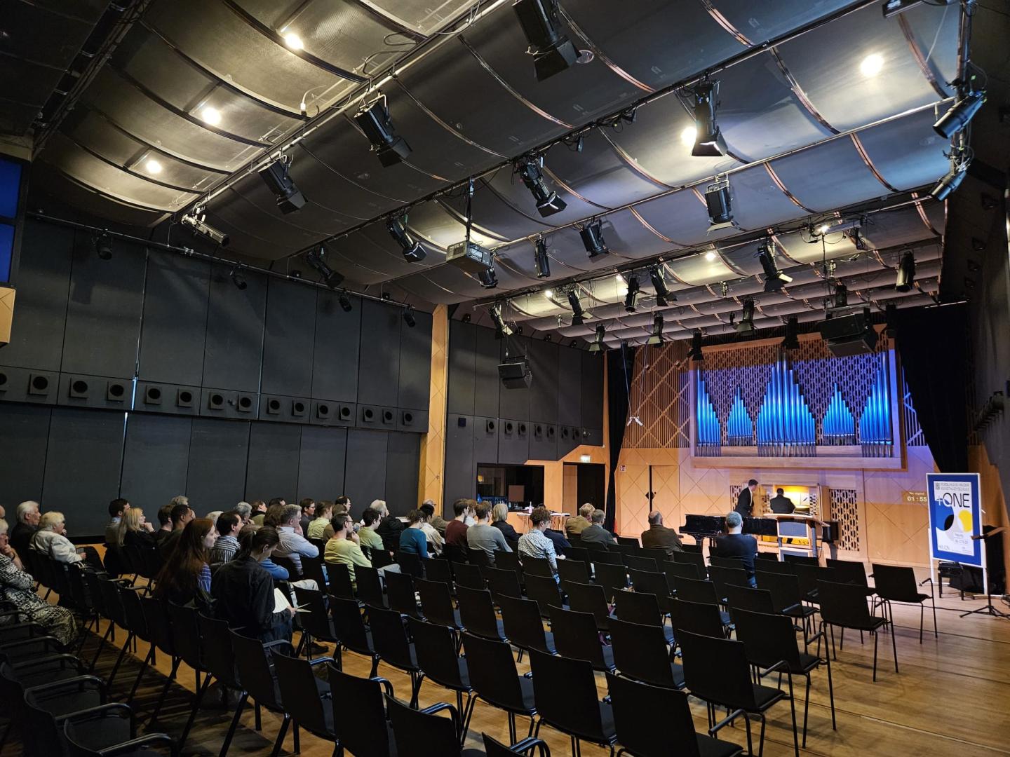 Blick in Kleinen Saal, Gruppe sitzt im Publikum, Lukas Euler spielt an der Kern-Orgel