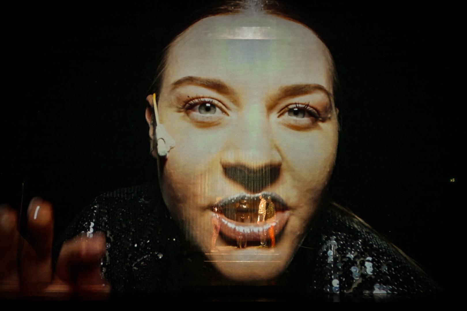 Videoprojektion des Gesichts einer Schauspielerin.