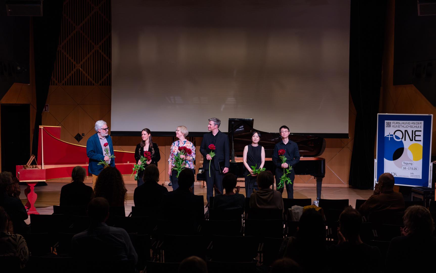 Lucas Fels, Kadra Dreizehnter, Melinda Paulsen, Andreas Frese, Dongju Seo und Jiaqi Chen mit Blumen beim Applaus im Kleinen Saal nach einem Konzert.