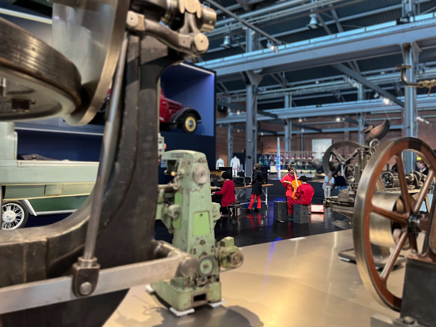 Menschen in roten Overalls musizieren im Industriemuseum