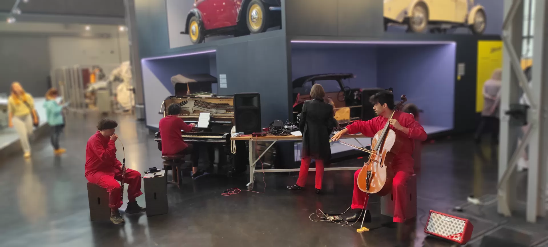 Vier rot-schwarz gekleidete Menschen musizieren im Industriemuseum