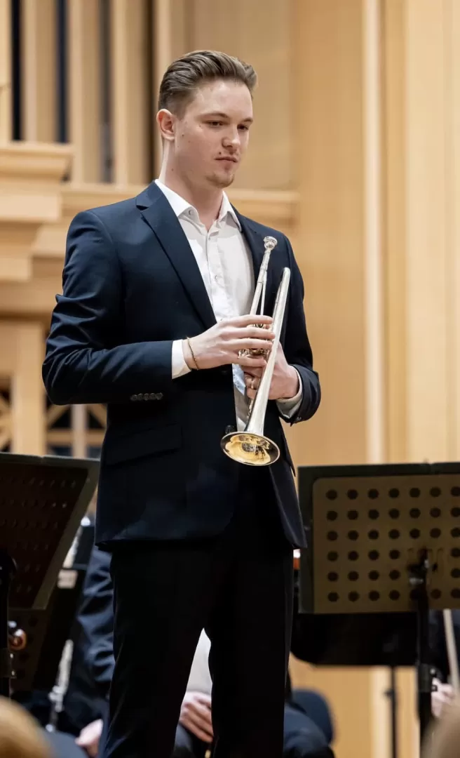 Levente Hanzlik steht auf der Bühne und hält die Trompete in der Hand.