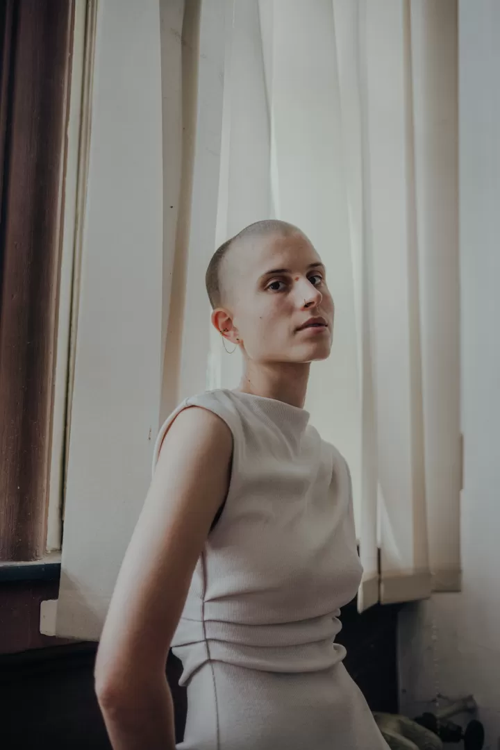 Lisa Freiberger blickt seitlich in die Kamer, sie trägt ein weißes Kleid.