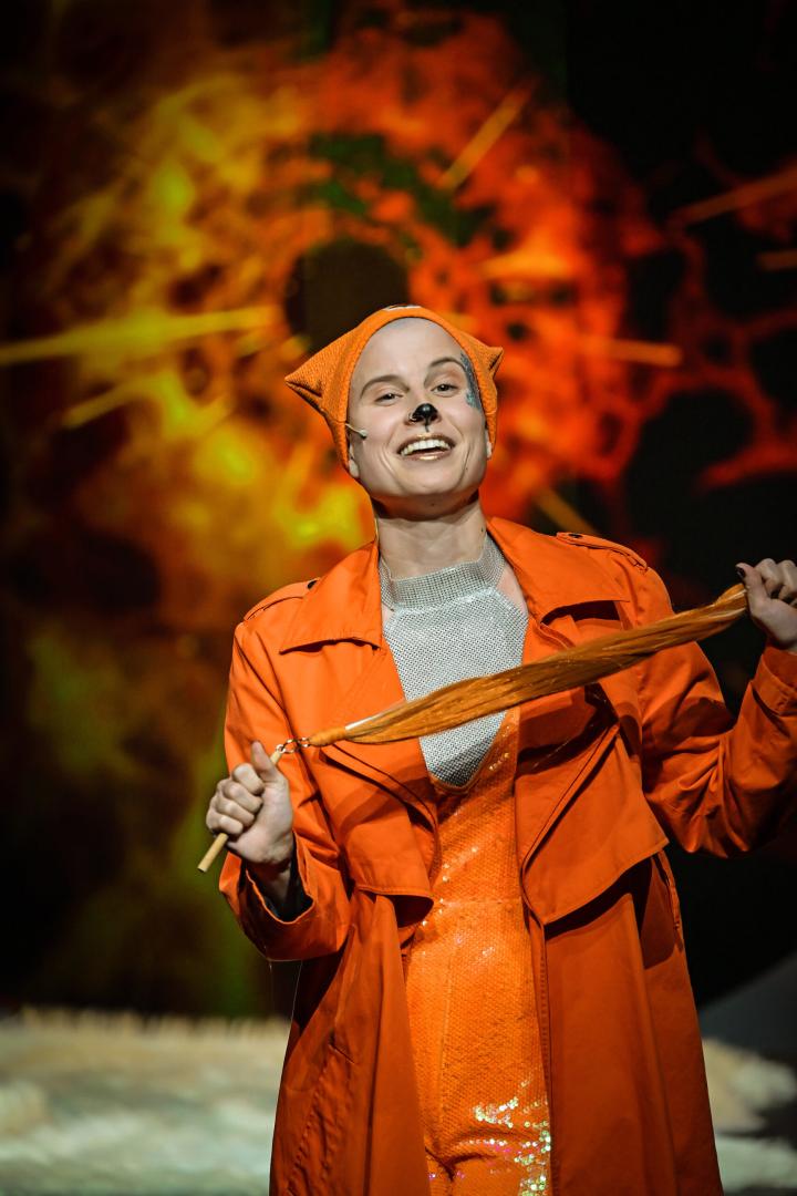 Lisa hält einen Fuchsschwanz in der Hand und lacht in die Kamera.