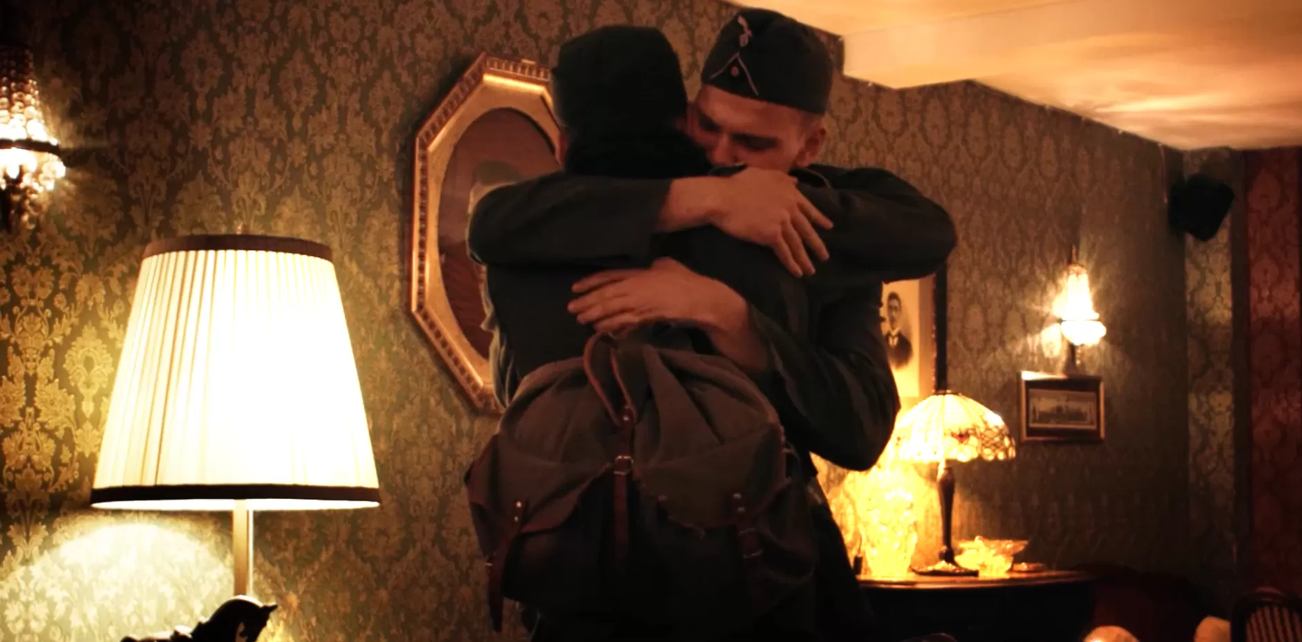 Zwei Männer in Wehrmachtsuniformen umarmen sich.