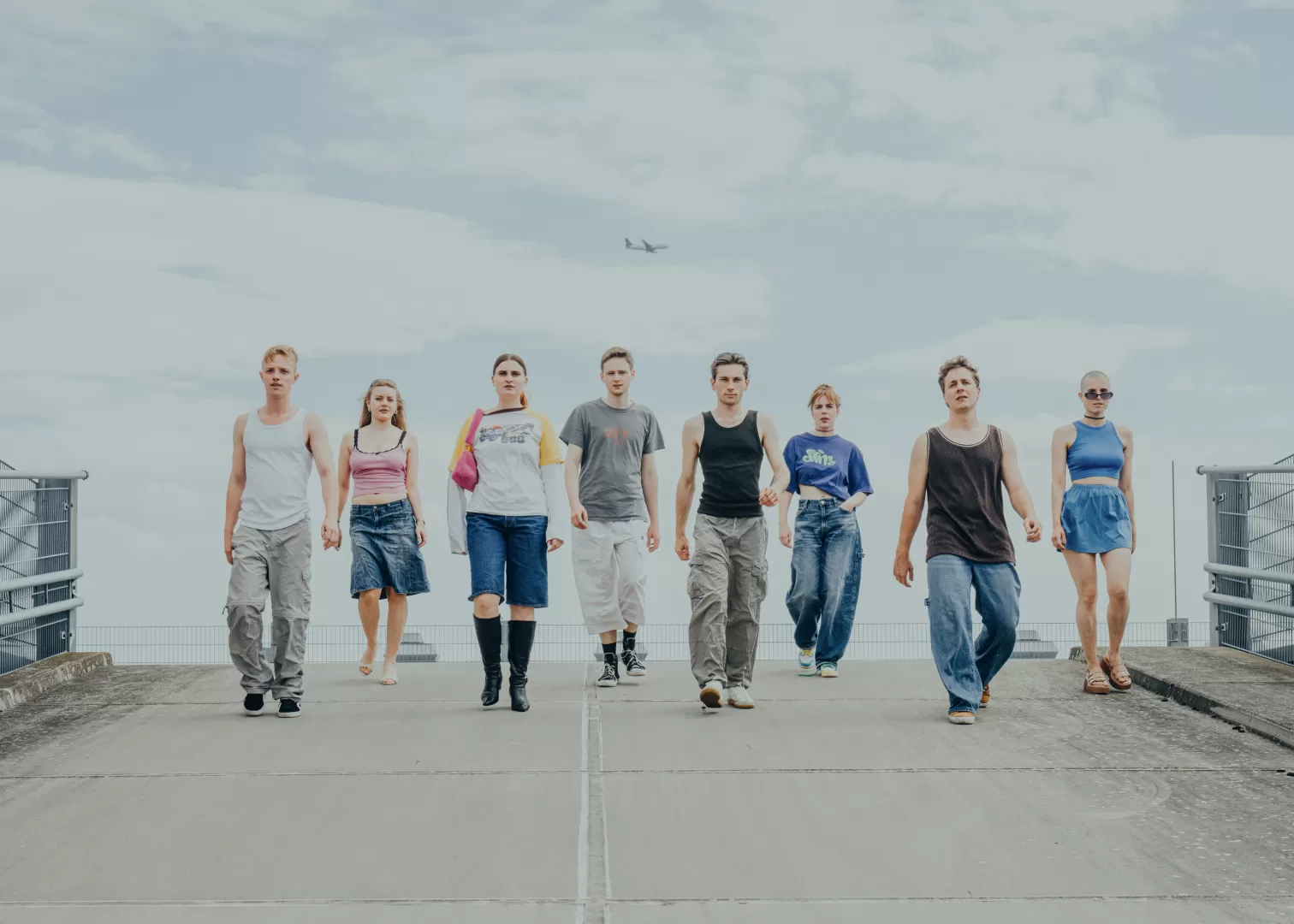 Gruppenfoto des Jahrgangs: Acht Personen gehen in einer Reihe eine Rampe herunter auf die Kamera zu.