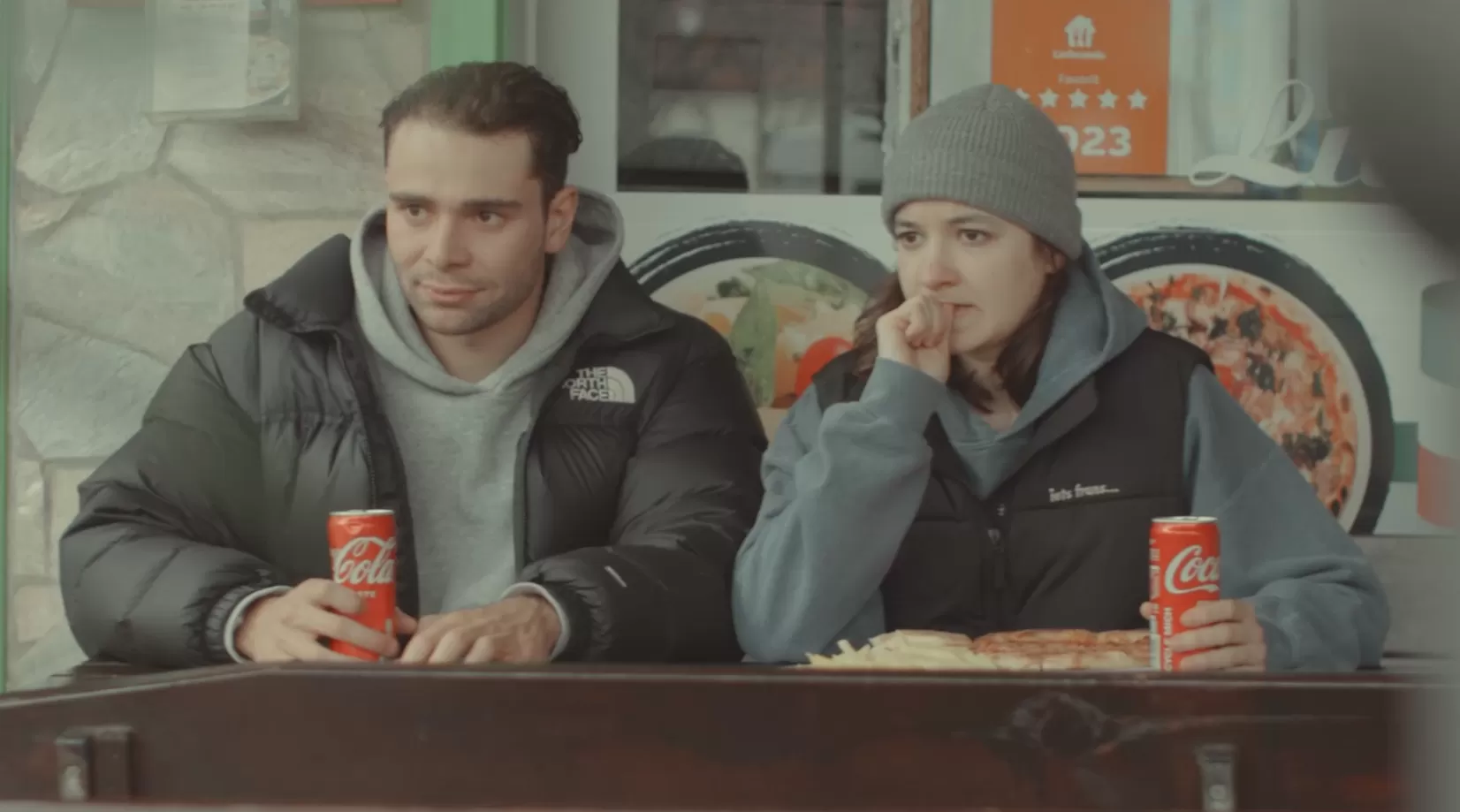 Zwei Personen auf der Terrasse einer Pizzaria.