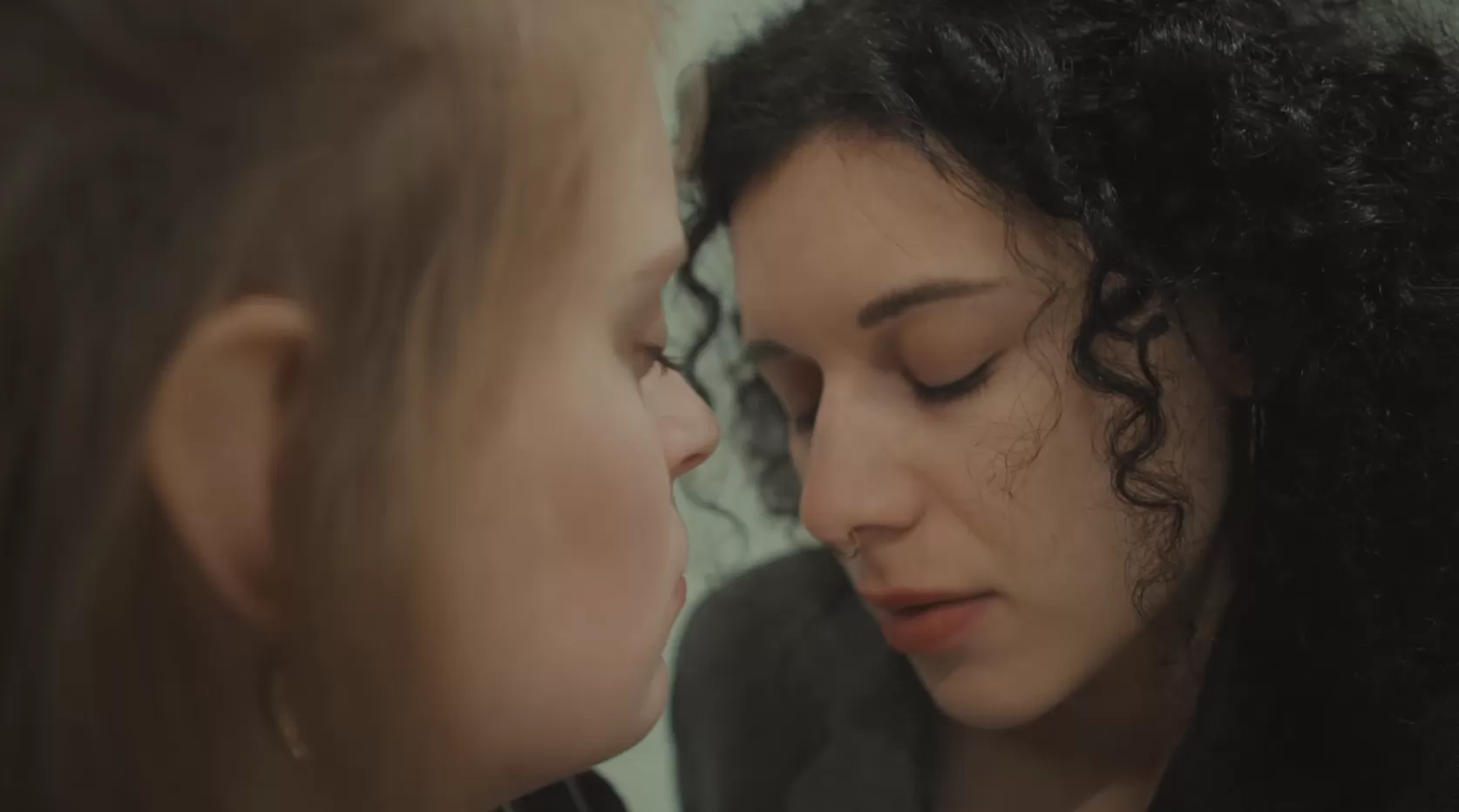 Zwei junge Frauen in einer Nahaufnahme, die Augen geschlossen.