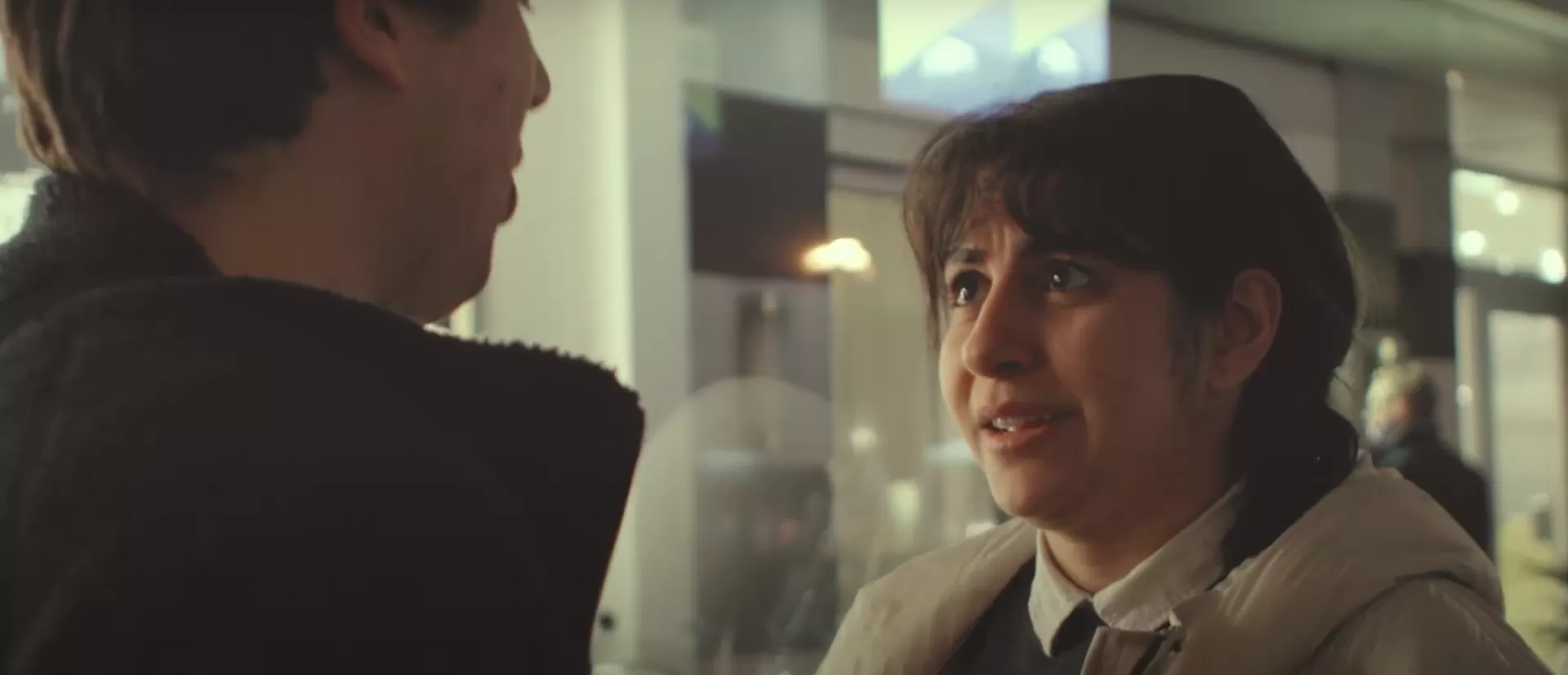 Zwei Personen vor einem Kinogebäude.