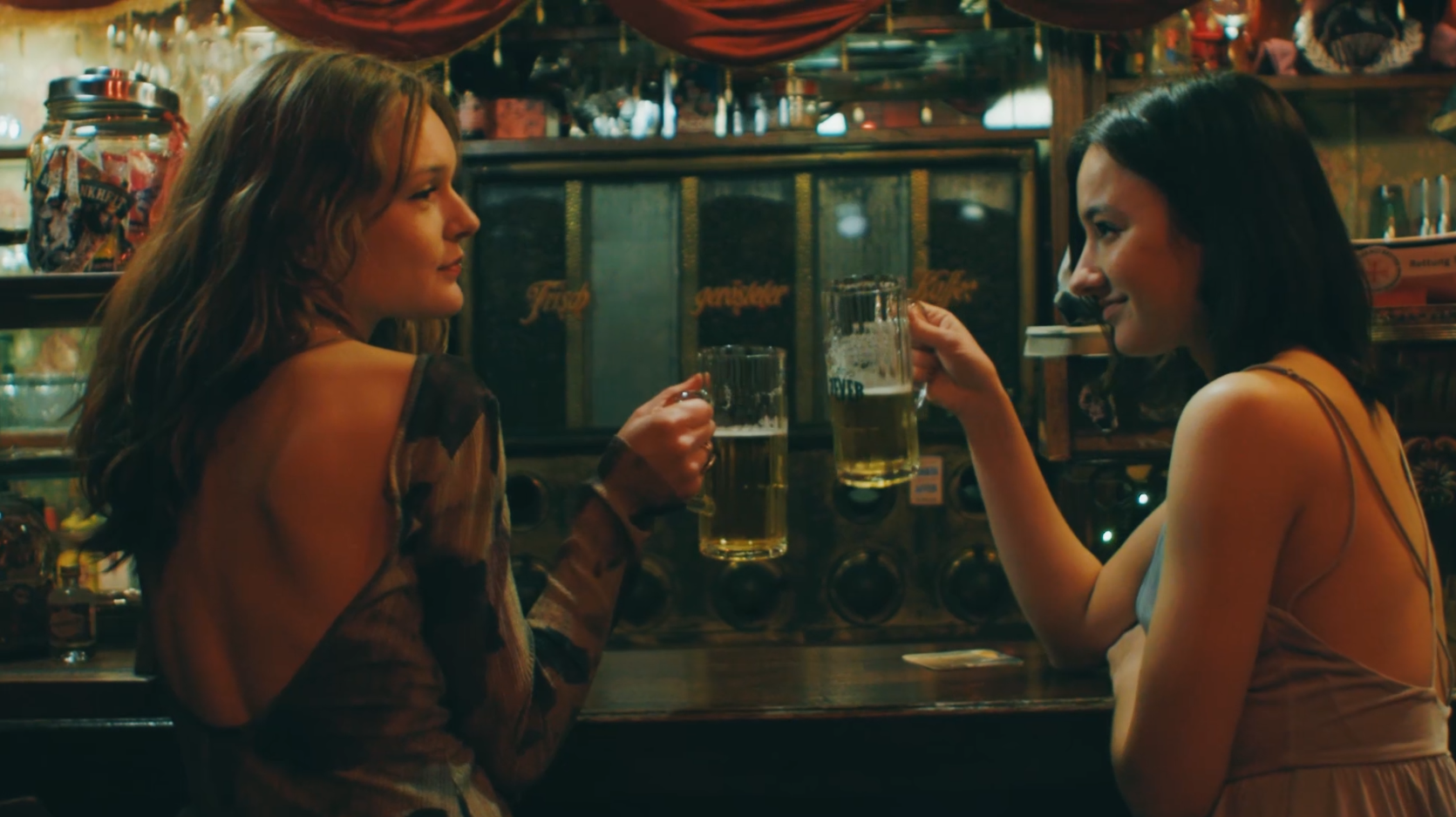 Zwei Frauen sitzen an einer Bar in einer Kneipe.