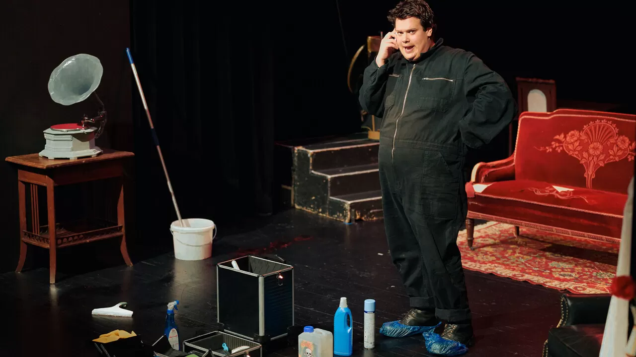 Eine Person steht im Overall in einem aum und telefoniert