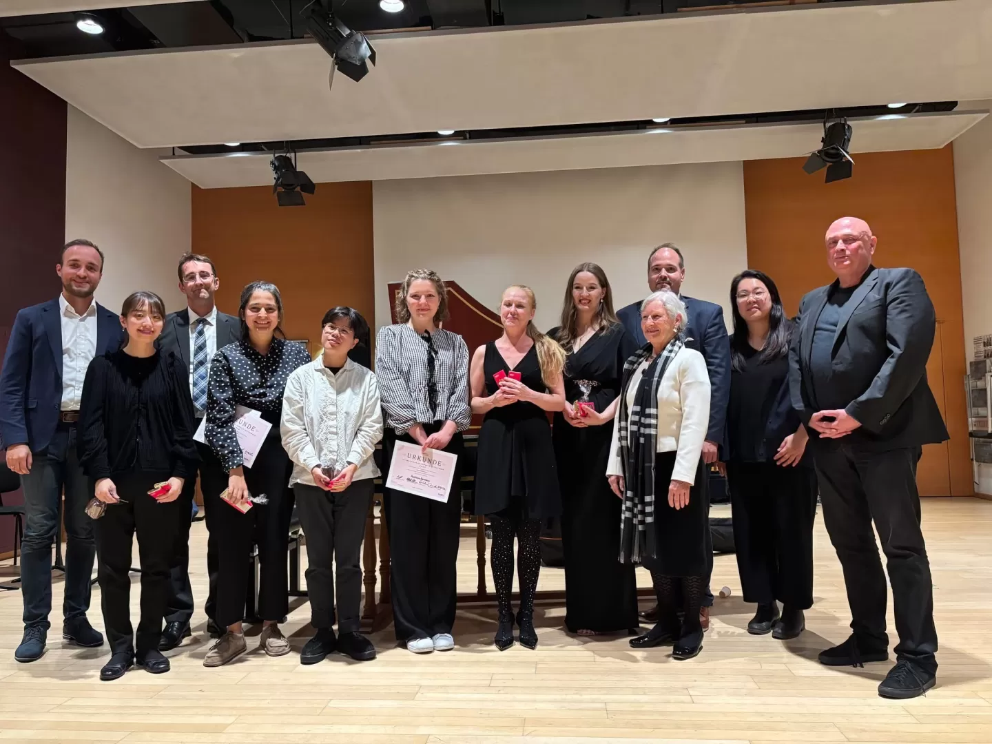 Ein Gruppenfoto, mehrere Menschen halten Urkunden in der Hand