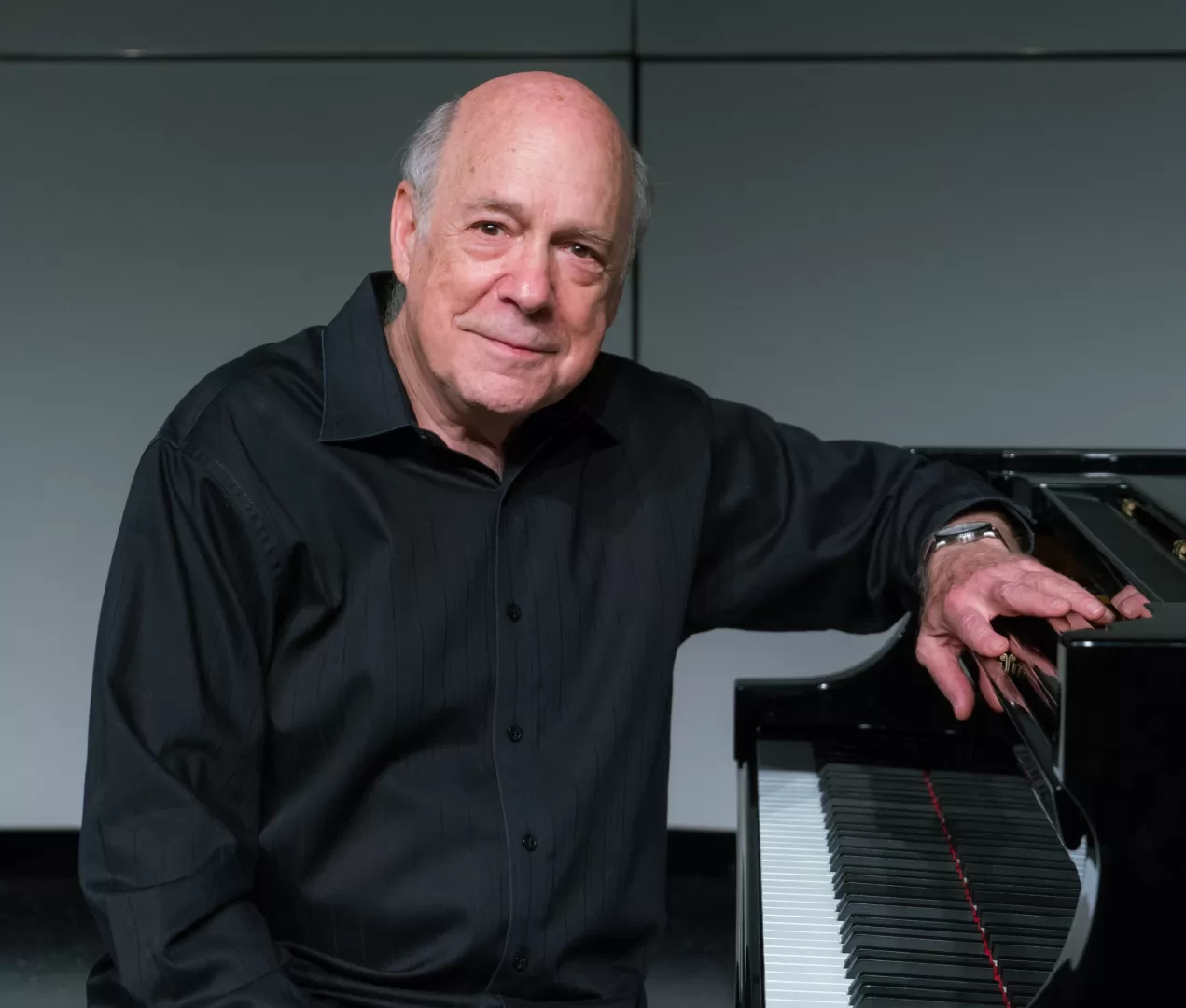 Porträtfoto von Victor Rosenbaum, der an einem Klavier sitzt.