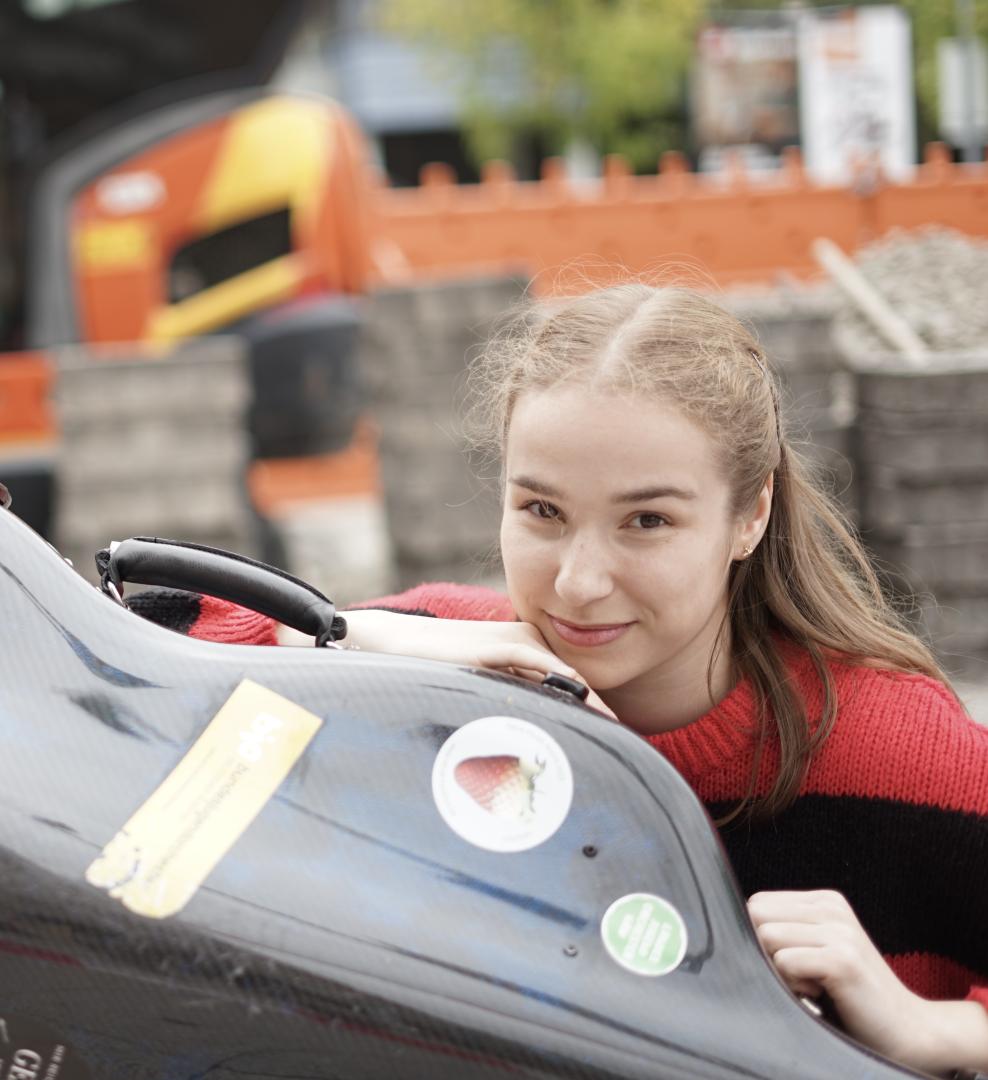 Porträt von Clara Stümke mit ihrem Instrumentenkasten