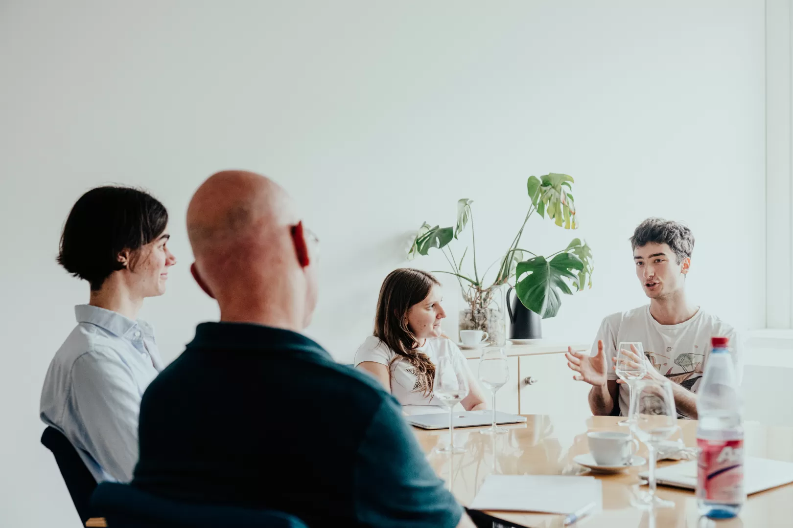 Drei Studierende sitzen mit dem Präsidenten am Tisch im Gespräch