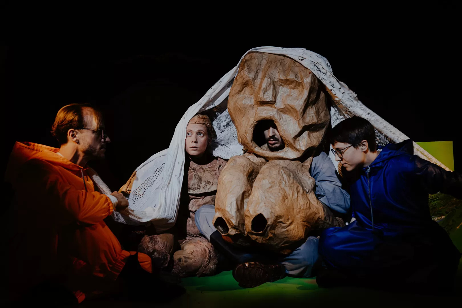 Mehrere Personen gemeinsam unter einer Decke.