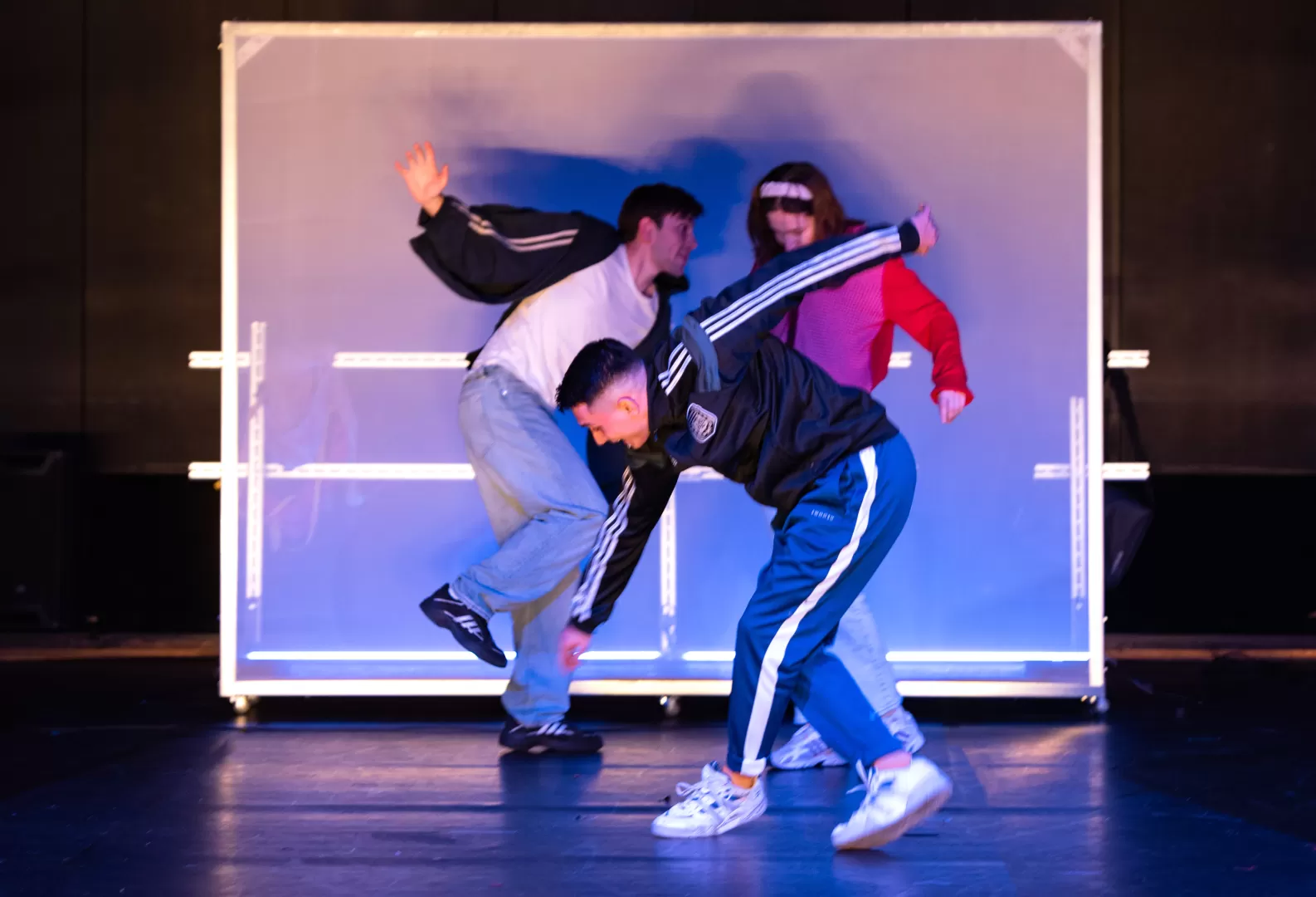 Drei Personen vor einer Stellwand.