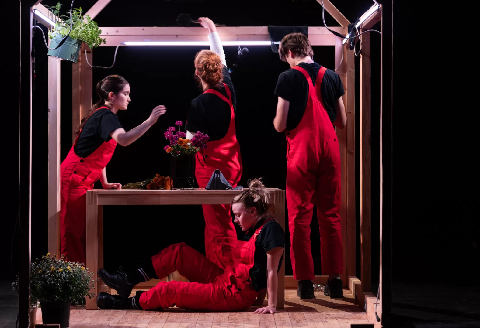 Vier Personen in roten Latzhosen.