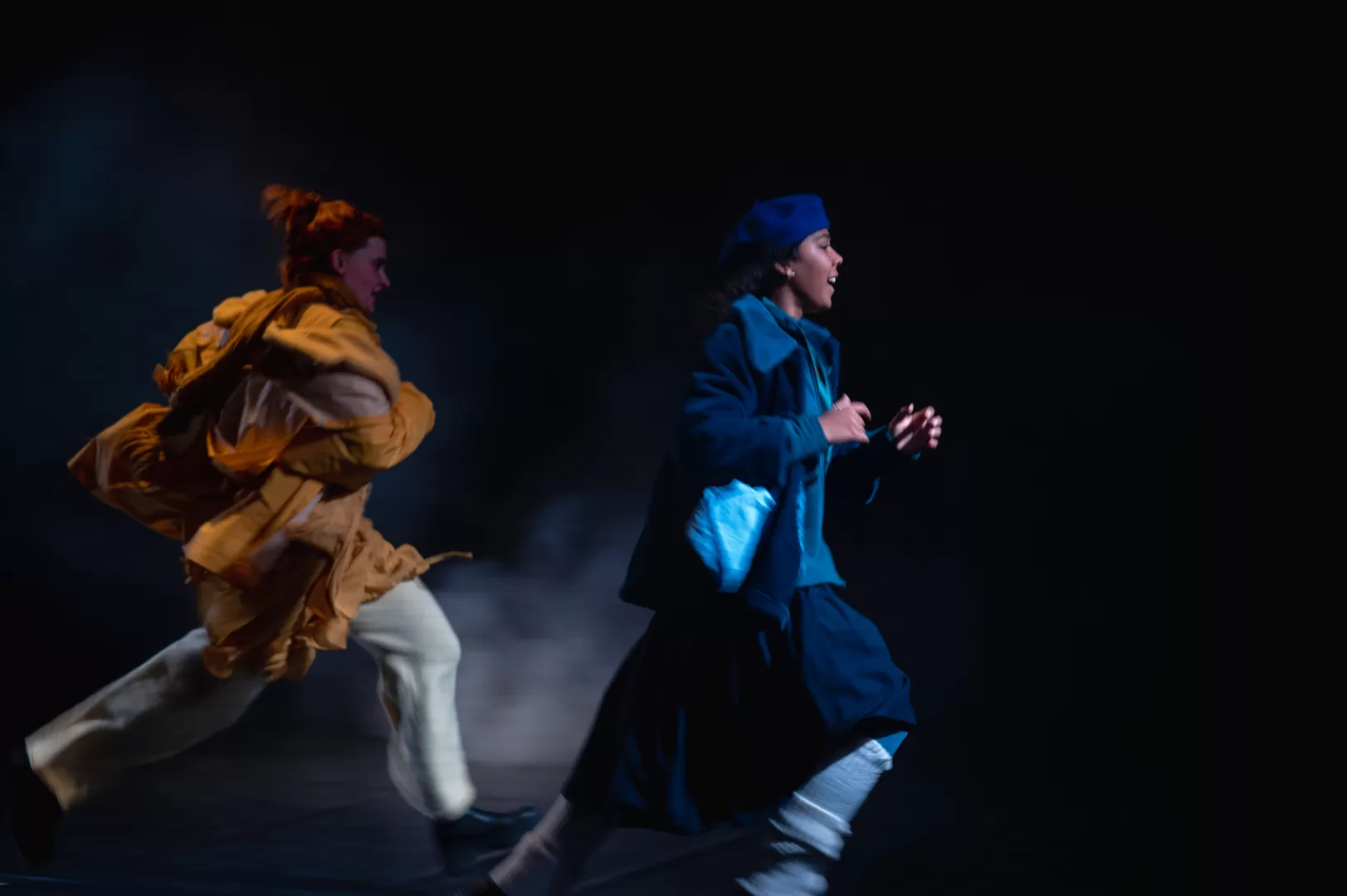 Zwei junge Frauen in Winterkleidung rennen.