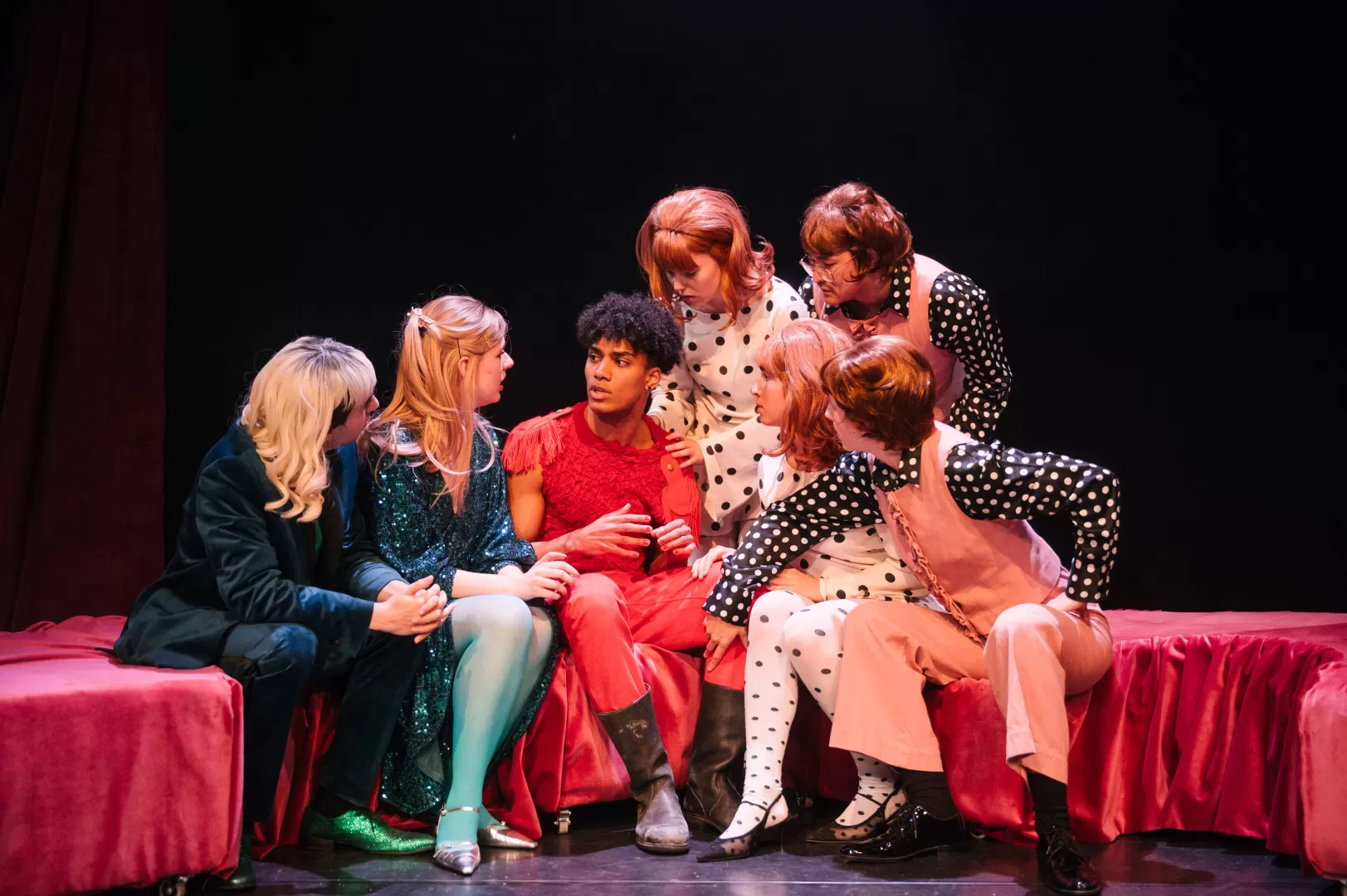 Fünf Personen sitzen um einen rot gekleideten Mann herum