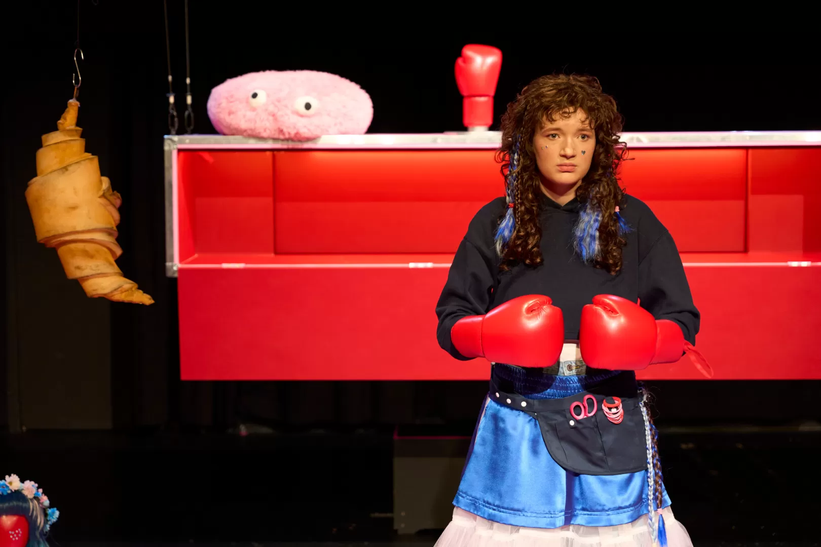 Eine junge Frau mit roten Boxhandschuhen.