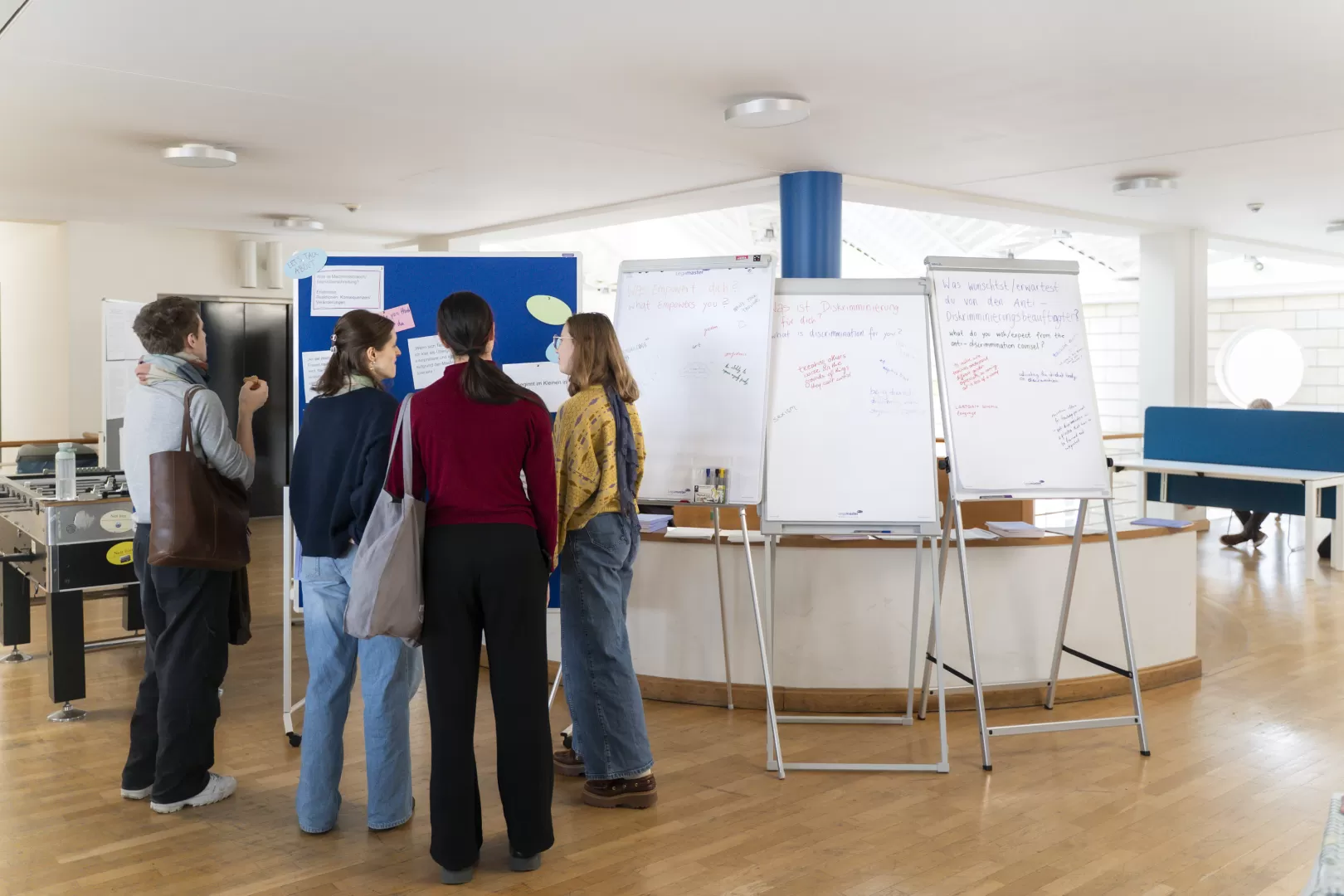 Studierendengruppe schaut sich eine Stellwand mit Notizen beim Aktionstag an