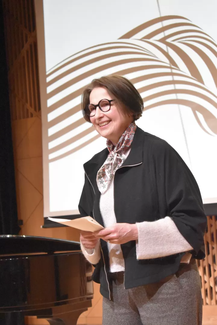 Constanze Rora steht mit einem Blatt in der Hand im Kleinen Saal der HfMDK.