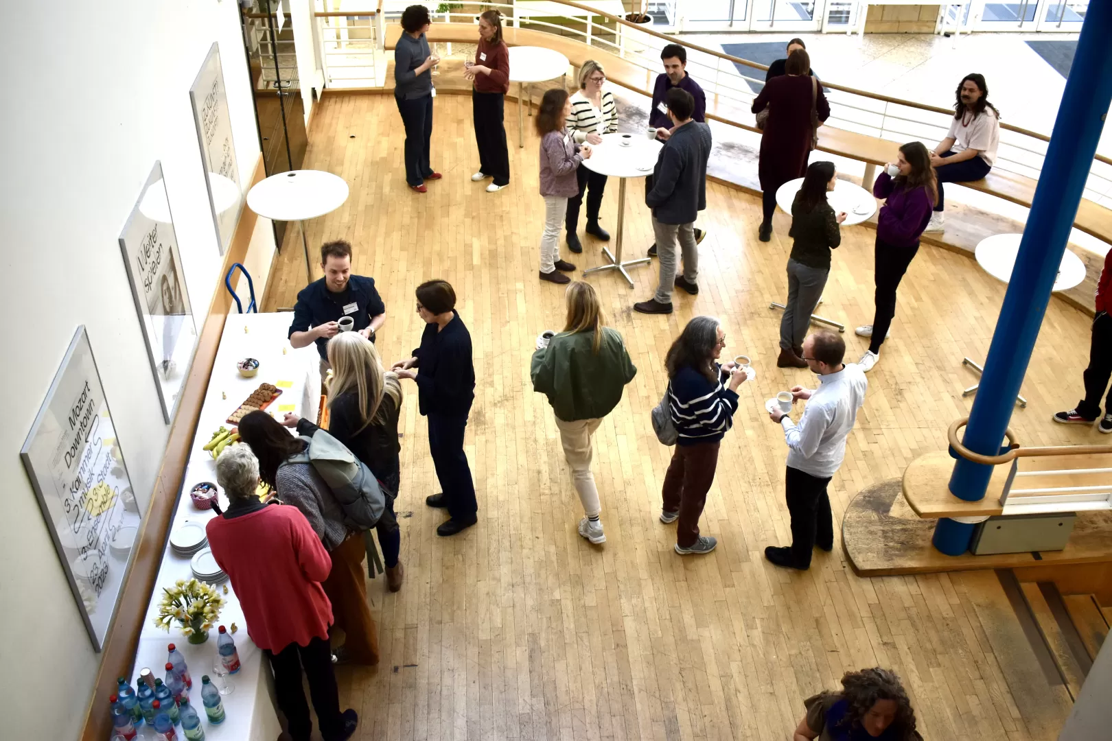 Das Foyer des Kleinen Saals der HfMDK, in dem am Buffet und an Stehtischen in kleinen Gruppen diskutiert wird.
