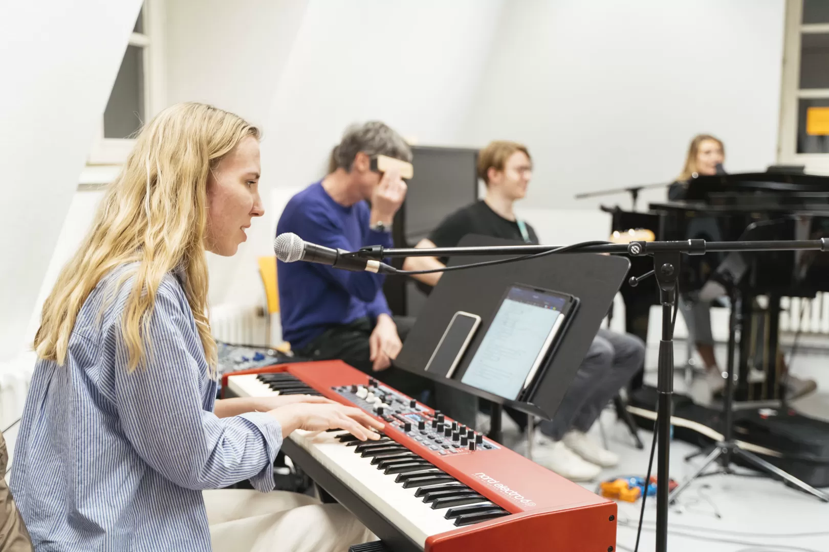 Bandprobe, bei der im Vordergrund eine Studentin am Keyboard sitzt und singt