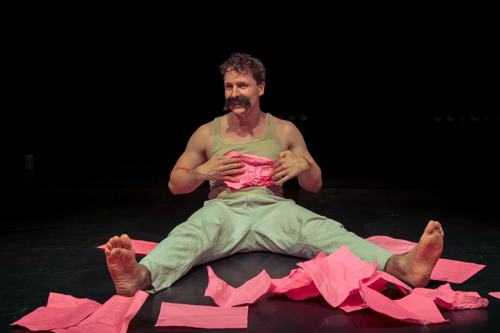 Mann mit Schnurrbart inmitten von pinken Papier.