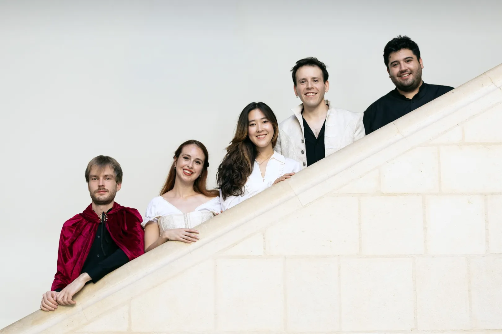 Die fünf Ensemblemitglieder des Ensembles Commedia dell'Arte stehen auf einer Treppe