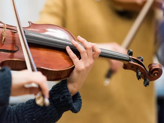 Detailaufnahme einer Hand auf dem Griffbrett einer Viola