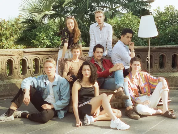 Abschlussjahrgang 2022 als Gruppe auf einem Sofa mit Stehlampe vor einer Mauer und Palmen.