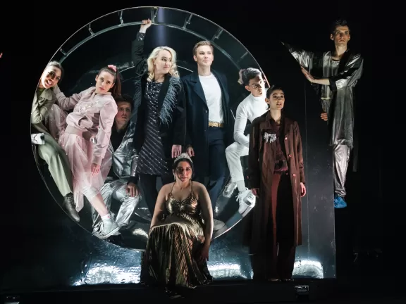 Gruppe steht in einem großen Metallrad.