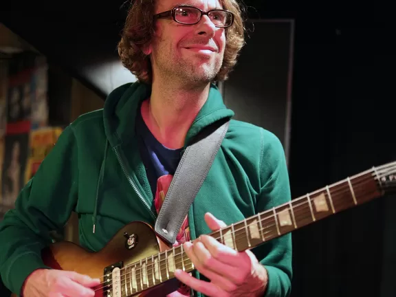 John Schröder spielt Gitarre.