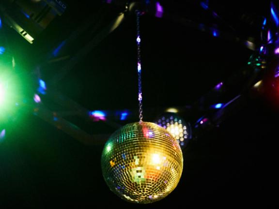 "The winner takes it all" ABBA-Liederabend Studiojahr Schauspiel Eine Discokugel wird gold angestrahlt