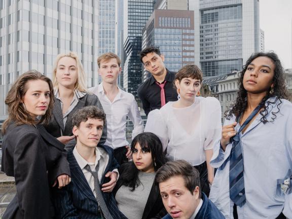 Eigenarbeiten der Schauspielabsolvierenden 2025 Neun Menschen stehen lachend vor einer Skyline