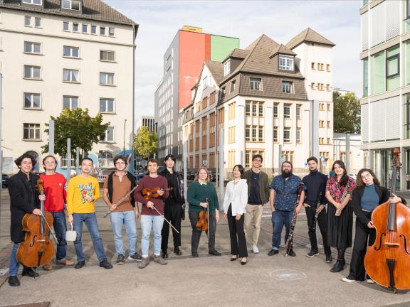 Gruppenfoto von Musiker*innen mit ihren Instrumenten