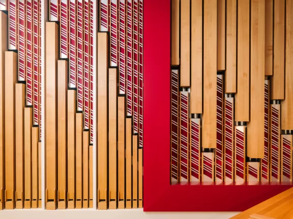Foto der Rieger Orgel an der HfMDK mit Details in rot und warmen Holztönen
